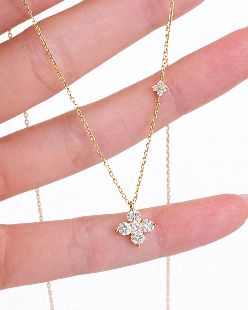Close-up detail of the Twin Four Clover Diamond Necklace in hand